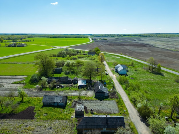 Luchtbeeld over een klein dorpje bij een onverharde weg Grote veelkleurige velden beplant met verschillende landbouwgewassen Tarweveld vanuit een vogelzicht