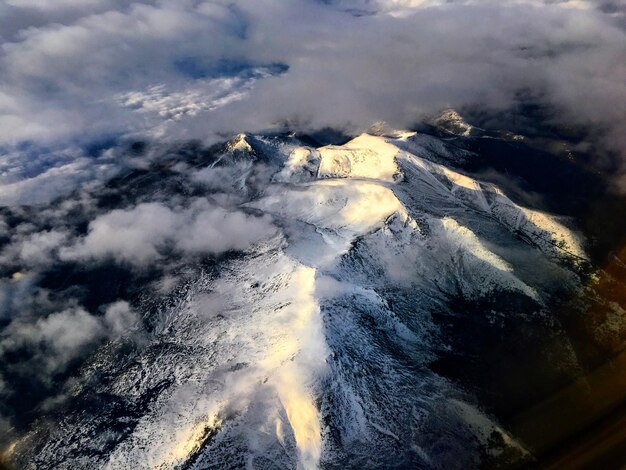 Foto luchtbeeld van besneeuwde bergen tegen de lucht
