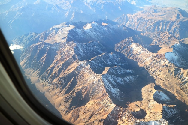 Luchtbeeld van de Andesgebergte gezien vanuit het raam van een vliegtuig tijdens een vlucht in Chili