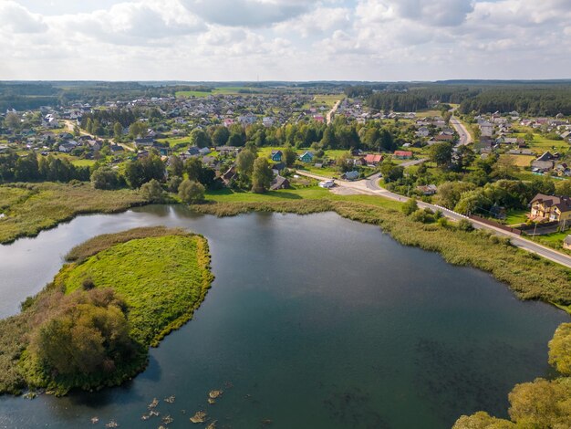 Luchtbeeld van de kronkelende rivier en de bloeiende velden De rivier stroomt langs landbouwvelden en bossen Een drone vliegt over velden bossen en rivieren Natuurlijk landschap