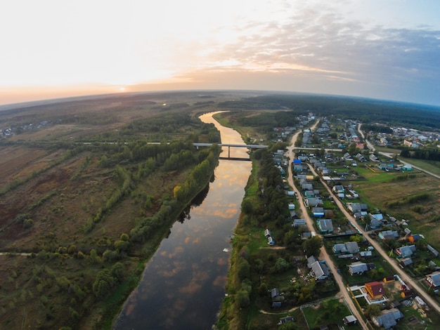 Luchtbeeld van de stad langs de rivier tegen de hemel bij zonsondergang