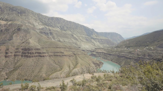 Luchtbeeld van een buigende rivier die over groene hoge heuvels stroomt en bedekt is met een curve van nevel.