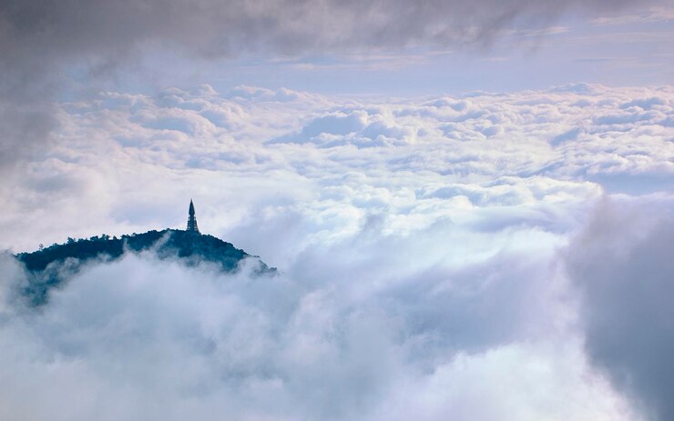 Foto luchtbeeld van een communicatietoren op een heuvel tegen wolken