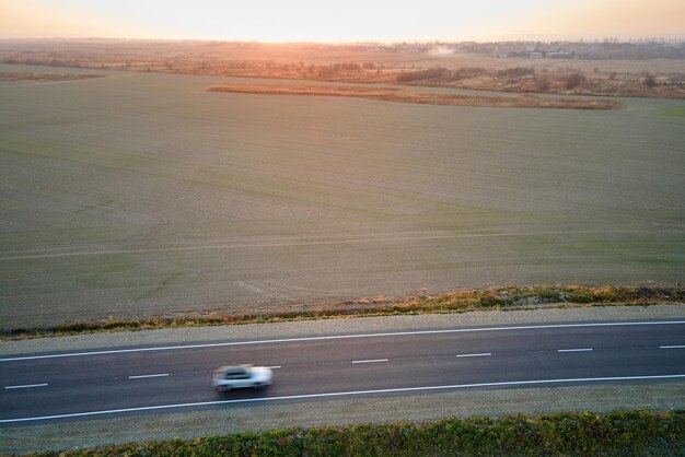 Foto luchtbeeld van een interstedelijke weg met wazig snel rijden milieuvriendelijke elektrische auto bij zonsondergang topbeeld van een drone van het snelwegverkeer in de avond