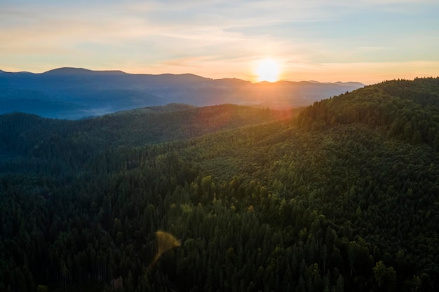 Foto luchtbeeld van een verbazingwekkend landschap met donkere bergheuvels bedekt met bos dennenbomen bij zonsopgang in de herfst prachtig wild bos bij dageraad