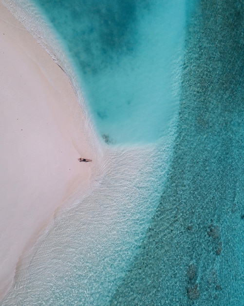Luchtbeeld van een vrouw die op het strand ligt