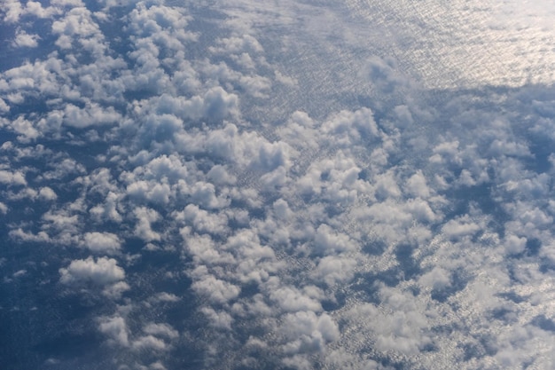 Luchtfoto avondlucht en wolken uitzicht boven de oceaan vanuit de patrijspoort van het vliegtuig