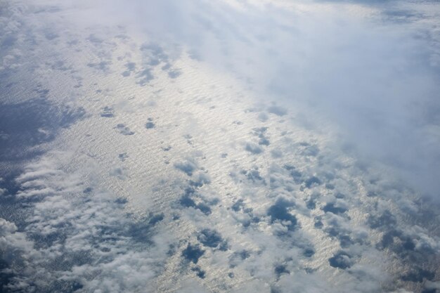 Luchtfoto avondlucht en wolken uitzicht boven de oceaan vanuit de patrijspoort van het vliegtuig