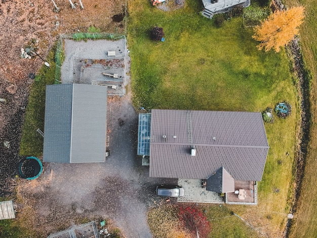 Luchtfoto boerderij in het midden van het bos, tractor en schuren. Foto genomen vanaf een drone. Finland, Pornainen.