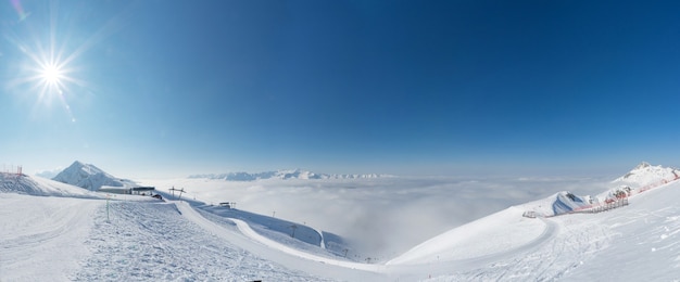 Luchtfoto boven de wolken Rosa Khutor Ski Resort bergen bedekt met sneeuw in Krasnaya Polyana