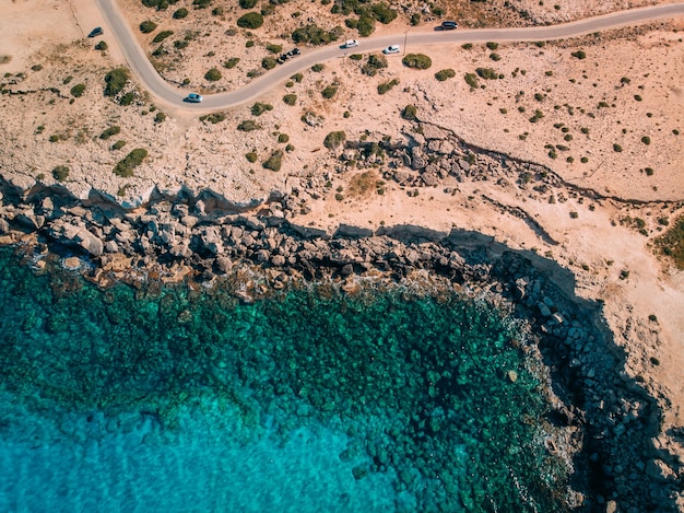 Luchtfoto boven Rotsachtige kust met kristalhelder blauw water in de buurt van Kaap Cavo Greco, Cyprus