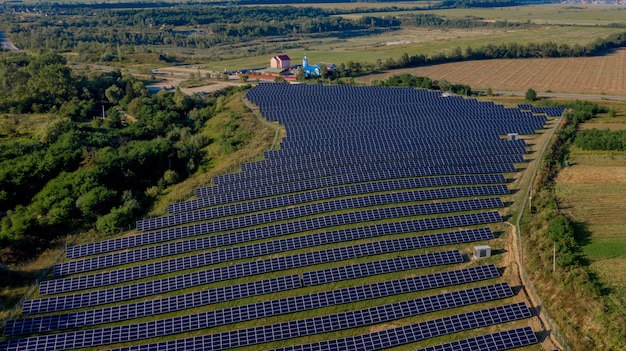 Luchtfoto bovenaanzicht op zonne-energiecentrale in groene veld op zonnige dag