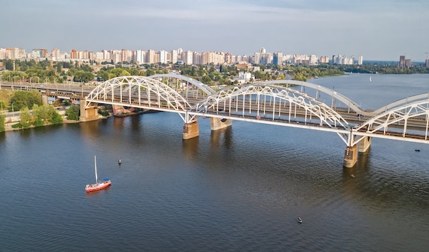 Luchtfoto bovenaanzicht van auto en spoorweg Darnitsky-brug over de Dnjepr van bovenaf, de skyline van de stad Kiev (Kiev), Oekraïne