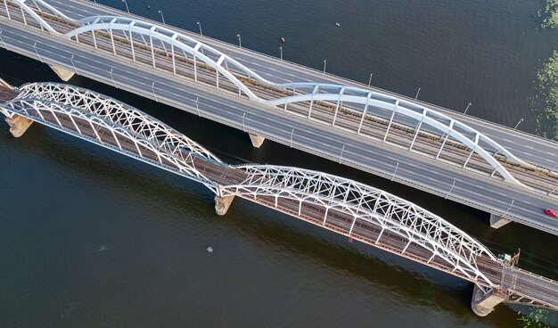 Foto luchtfoto bovenaanzicht van auto en spoorweg darnitsky-brug over de dnjepr van bovenaf, de skyline van de stad kiev (kiev), oekraïne