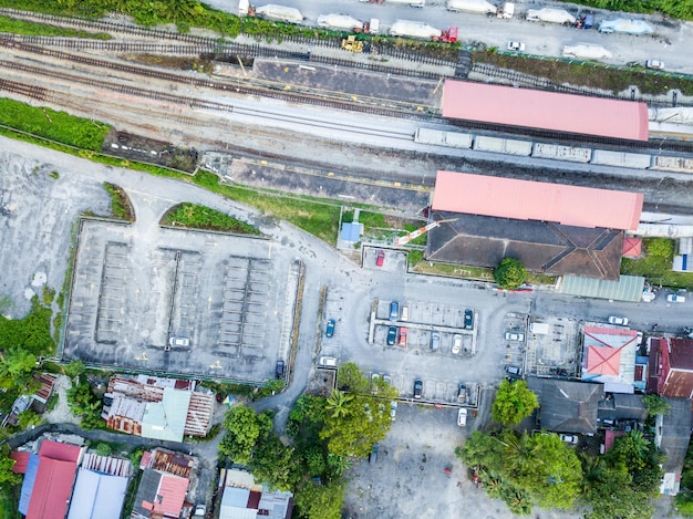Luchtfoto bovenaanzicht van parkeerplaats en spoorlijn naast de landelijke huizen in maleisië