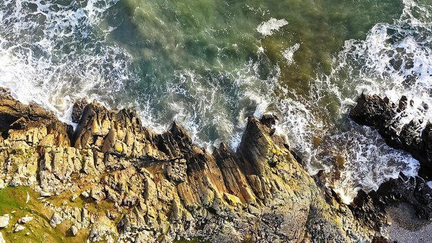 Luchtfoto bovenaanzicht van prachtige brekende oceaangolven tegen een ruige rotsen