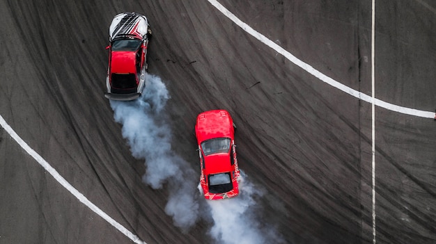 Luchtfoto drift strijd, Twee auto&#39;s drijven slag op circuit met rook.