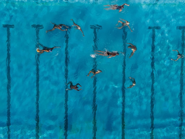 Luchtfoto drone bovenaanzicht shot van mensen die strijden in waterpolo in turquoise waterzwembad