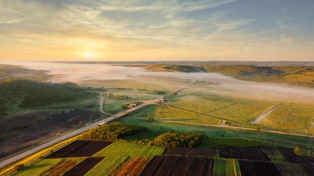 Luchtfoto drone uitzicht op de natuur in Moldavië in de ochtend. Velden en lage heuvels met mist in de lucht