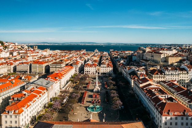 Luchtfoto drone uitzicht op het Rossio-plein met de rivier de Taag op de achtergrond in de wijk Baixa in Lissabon, Portugal