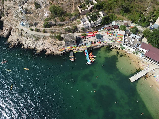 Luchtfoto drone-weergave op kleurrijke kajaks gegroepeerd bij een dok in de zeebaai-groep gelukkige kajakkers zijn