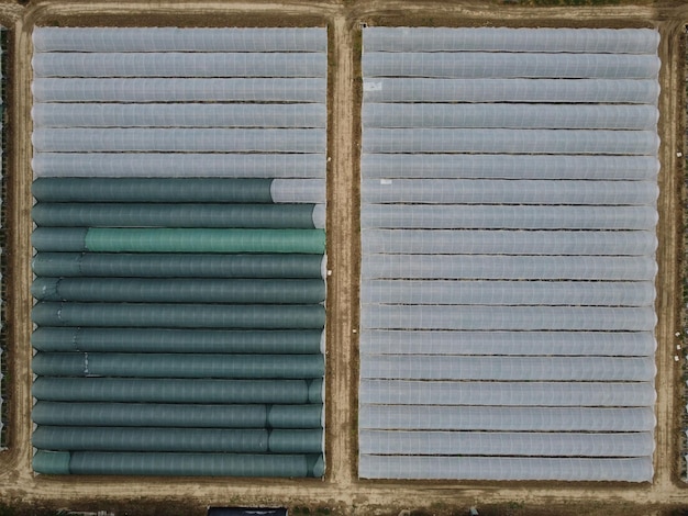 Luchtfoto drone-weergave van enorme gebieden kas voor het verbouwen van groenten glastuinbouw landbouwindustrie vliegen 's avonds over grote industriële kassen