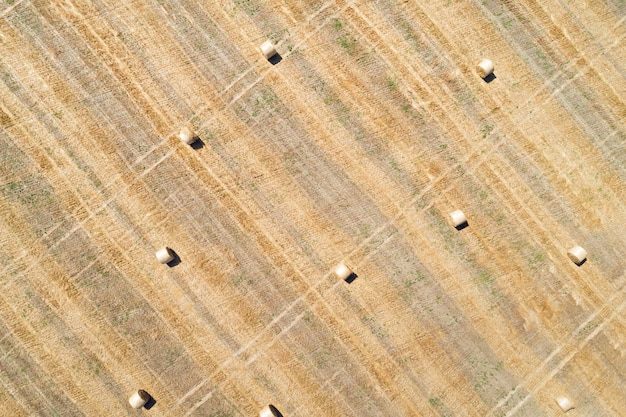 Luchtfoto drone weergave van gemaaid veld met verspreide hooibaal rollen