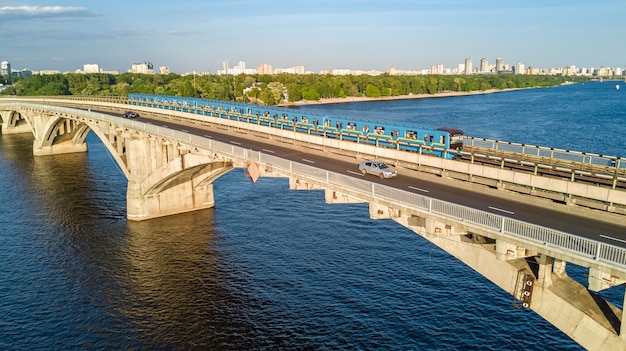 Luchtfoto drone weergave van Metro spoorbrug met trein en rivier de Dnjepr van bovenaf, skyline van de stad Kiev, Kiev stadsgezicht, Oekraïne