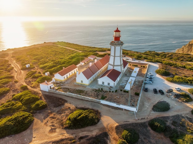 Luchtfoto drone weergave van vuurtoren op Cabo Espichel Kaap Espichel aan de Atlantische Oceaan bij zonsondergang. Sesimbra, Portugal