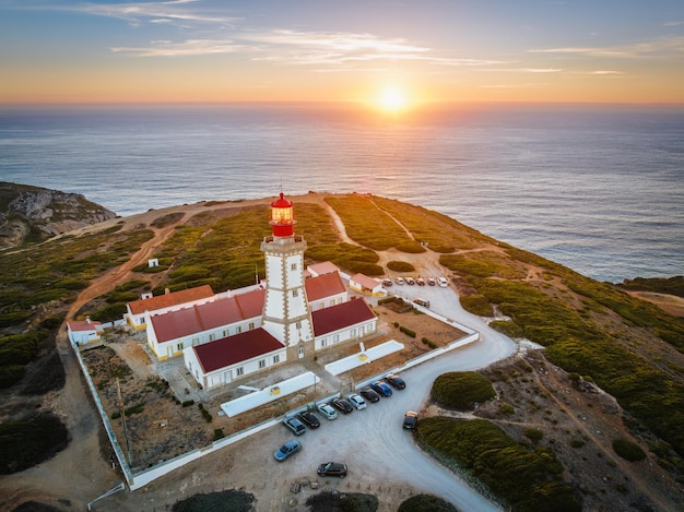 Luchtfoto drone weergave van vuurtoren op Cabo Espichel Kaap Espichel aan de Atlantische Oceaan bij zonsondergang. Sesimbra, Portugal