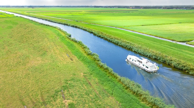 Luchtfoto drone weergave van woonboot in kanaal en land landschap van Holland van bovenaf, familie reizen per binnenschip en vakantie in Nederland