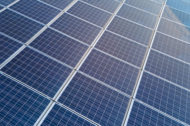 Luchtfoto gebouw dak met rijen blauwe fotovoltaïsche zonnepanelen voor het produceren van schone ecologische elektrische energie Hernieuwbare elektriciteit met nul-emissie concept