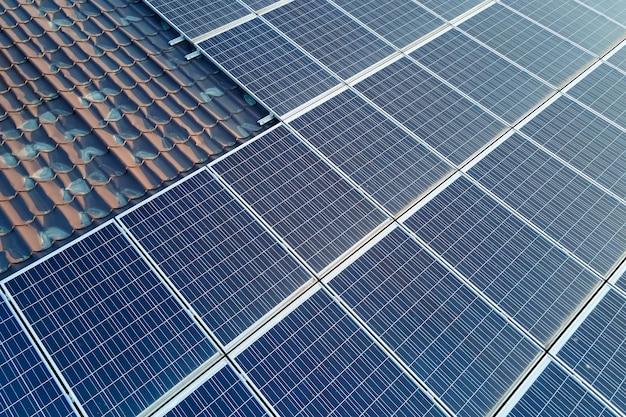 Luchtfoto gebouw dak met rijen blauwe fotovoltaïsche zonnepanelen voor het produceren van schone ecologische elektrische energie. Hernieuwbare elektriciteit met nul-emissieconcept.