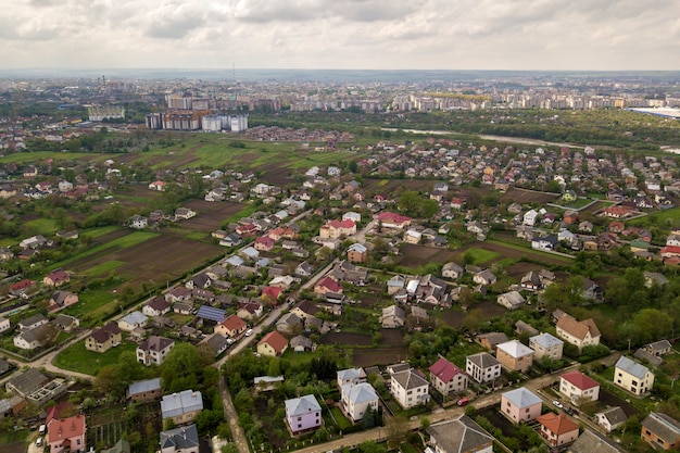 Luchtfoto landschap van kleine stad of dorp met rijen van residentiële huizen en groene bomen.