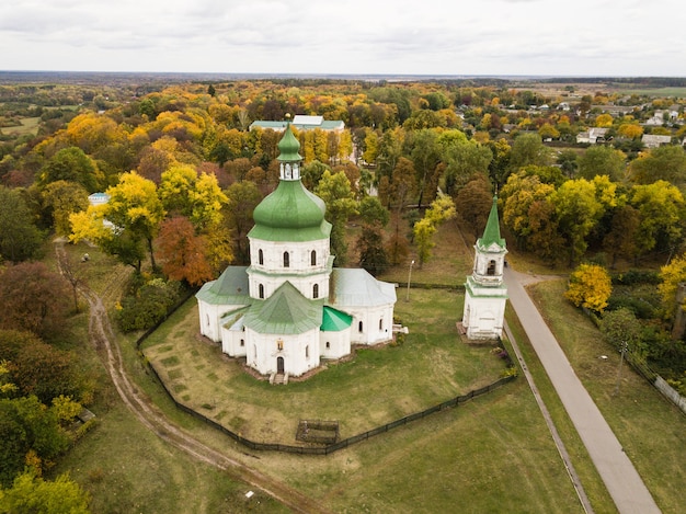 Luchtfoto naar provinciaal dorp Sedniv en Kerk van de Wederopstanding in de herfst, regio Chernihiv, Oekraïne