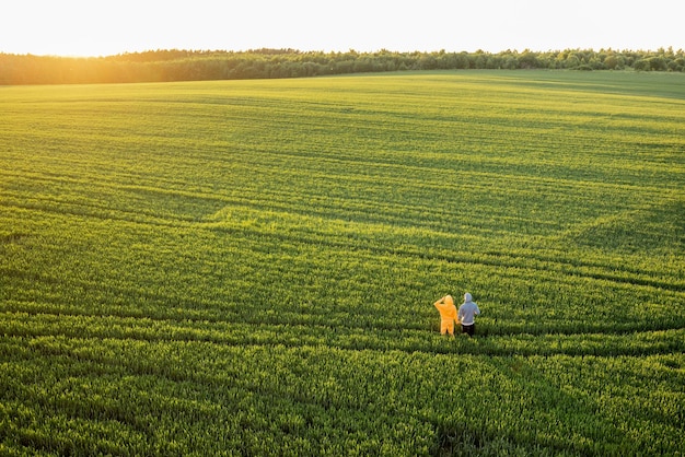 Luchtfoto op groen tarweveld met paar dat op pad loopt