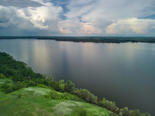 Luchtfoto op turquoise meer en groen bos aan de baai