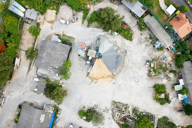 Luchtfoto panorama van boven naar beneden van zichtbare cementopslagtorens en betonmengmachines Een hoop zand en grind Industrieel achtergrondconcept