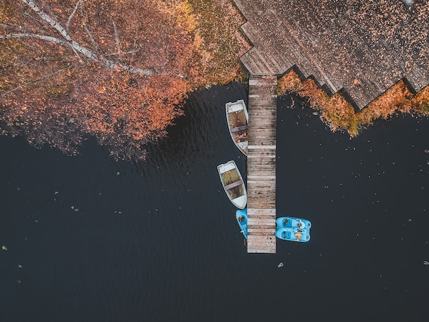 Luchtfoto pier met houten boten aan de oever van een schilderachtig meer, herfst bos. St. Petersburg, Rusland.