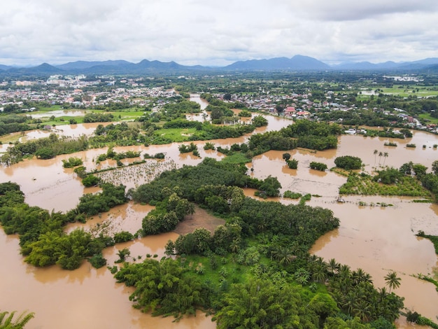 Luchtfoto rivier overstroming dorp platteland azië en bos boom bovenaanzicht rivier met water overstroming van bovenaf razende rivier die door de jungle stroomt meer stromend wild water na de regen