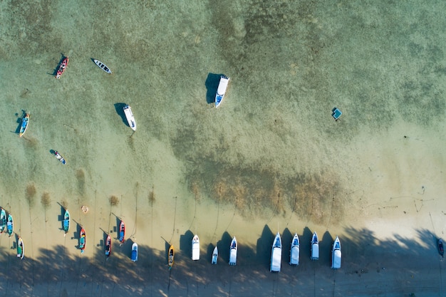 Luchtfoto top-down van thaise traditionele longtail vissersboten in het tropische zee prachtige strand in phuket thailand.