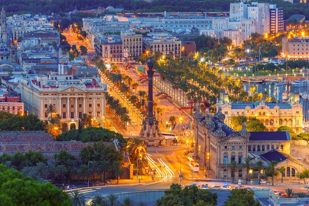 Luchtfoto uitzicht over plein Portal de la pau en Port Vell jachthaven en Columbus Monument 's nachts in Barcelona, Catalonië, Spanje