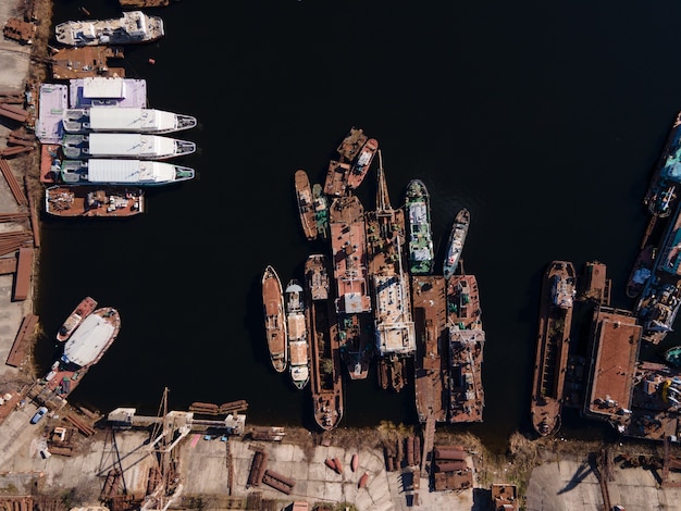 Luchtfoto van afgemeerde oude binnenschepen en schepen in de rivierhaven