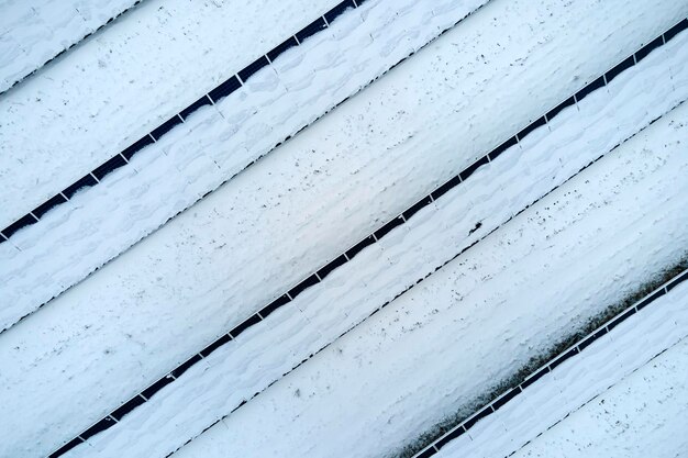 Luchtfoto van besneeuwde duurzame elektriciteitscentrale met rijen fotovoltaïsche zonnepanelen voor het produceren van schone elektrische energie Lage effectiviteit van hernieuwbare elektriciteit in de noordelijke winter