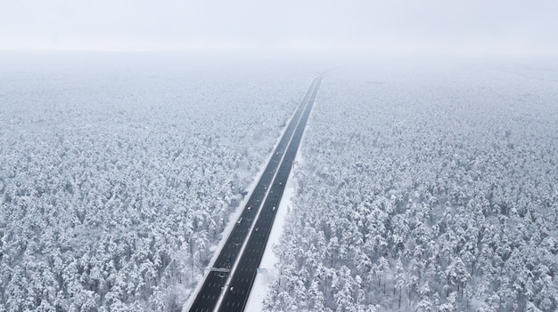 Luchtfoto van besneeuwde weg in de winter bos, vrachtwagen passeren, motion blur