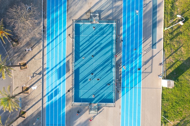 Luchtfoto van blauw kunstmatig voetbal- en basketbalveld