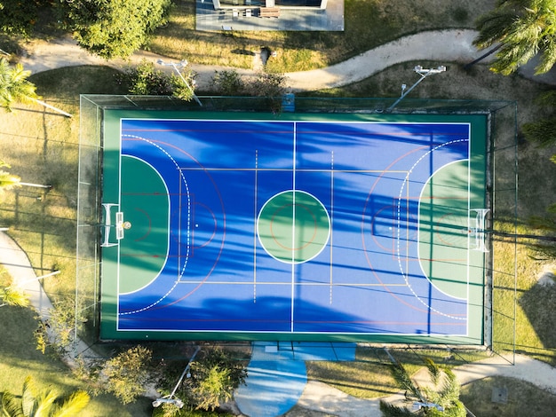 Luchtfoto van blauw multisportveld in het park Gebruikt om voetbal, basketbal of volleybal te oefenen Bovenaanzicht Zonnige dag Zonsondergang Drone-foto