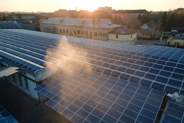 Luchtfoto van blauwe fotovoltaïsche zonnepanelen gemonteerd op het dak van een industrieel gebouw voor het produceren van groene ecologische elektriciteit Productie van duurzaam energieconcept