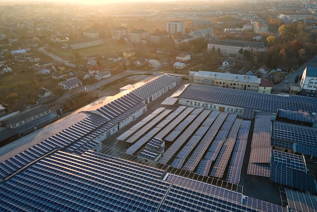 Luchtfoto van blauwe fotovoltaïsche zonnepanelen gemonteerd op het dak van een industrieel gebouw voor het produceren van groene ecologische elektriciteit Productie van duurzaam energieconcept