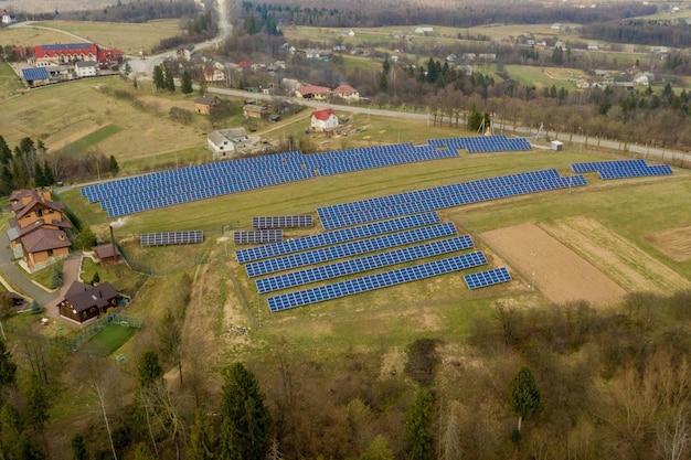 Luchtfoto van blauwe zonne-fotovoltaïsche panelen systeem produceren van hernieuwbare schone energie op het platteland